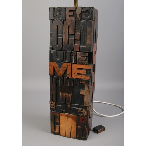 116 - A wooden table lamp made with printing press letters with shade. Lamp height: 40.5cm.