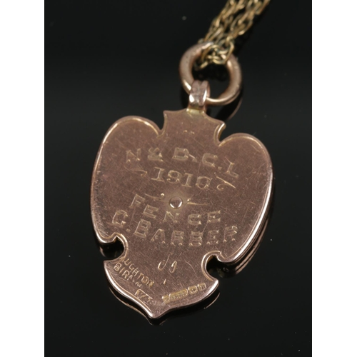 362 - WITHDRAWN A 9ct gold and enamel fob medal on a yellow metal chain. Presented to G Barber in 1910. Me... 