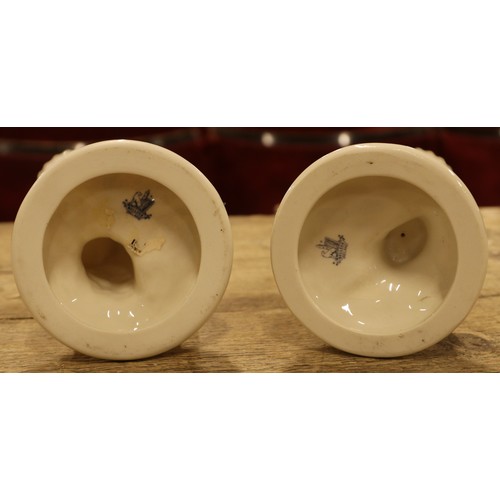 402 - A pair of Belleek creamware spill vases of a boy and a girl. (22cm height)