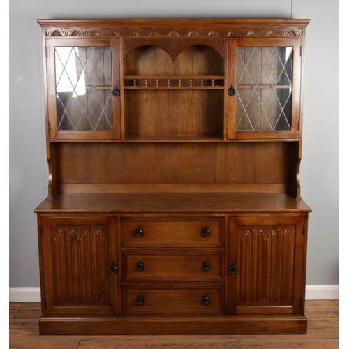 533 - A carved oak dresser with central spindle gallery and lead glazed upper doors. Height: 178cm, Width:... 