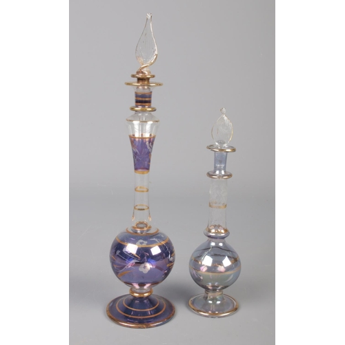 69 - Three glass perfume bottles. To include two possibly Egyptian bottles with leaf stoppers. Tallest: H... 