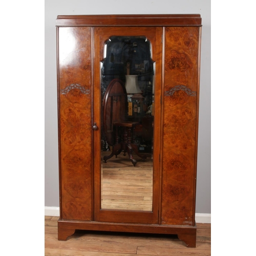 519 - A carved mahogany and walnut mirror front wardrobe.