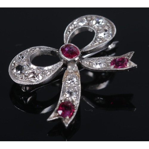 116 - An Art Deco ruby and diamond brooch in the form of a bow. 2cm x 2.2cm. 3.37g.