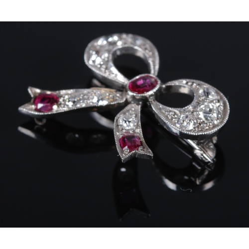 116 - An Art Deco ruby and diamond brooch in the form of a bow. 2cm x 2.2cm. 3.37g.