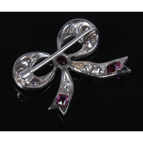 116 - An Art Deco ruby and diamond brooch in the form of a bow. 2cm x 2.2cm. 3.37g.