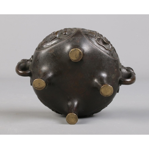 100 - A Chinese bronze lidded censor. The lid surmounted with a temple lion and having elephant mask handl... 