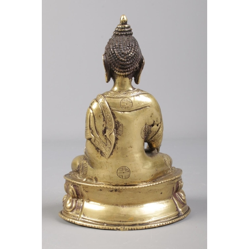 101 - A 19th century Sino Tibetan bronze devotional statue of a seated Buddha raised on lotus plinth.