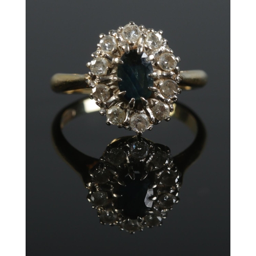 119 - An 18ct gold sapphire and diamond halo set ring. Size O. 5.2g. Sapphire size approximately 0.9cm x 0... 