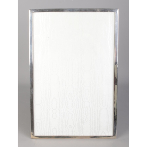 34 - A large silver easel photograph frame. Stamped Silver. 46cm x 31cm.