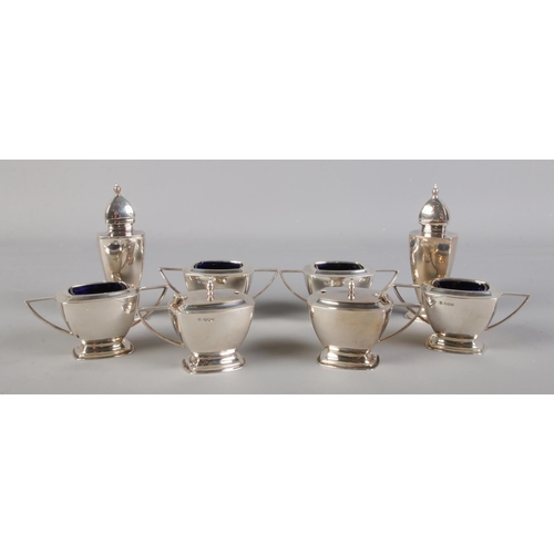 36 - A George VI silver eight part condiment set comprising of a pair of pepperettes, a pair of mustard p... 