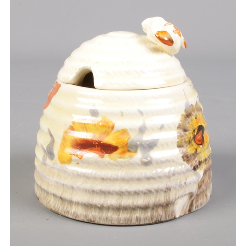 4 - A Wilkinson Ltd Clarice Cliff beehive honey pot decorated in the Rhodanthe design. 10cm.