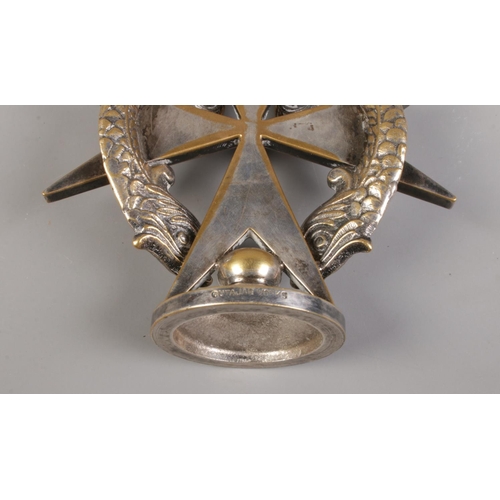 49 - A silver plated Cutajar Works car mascot formed as a Maltese cross surmounted with two dolphins.