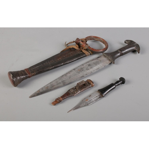 72 - An African tribal double edge dagger in scabbard, possibly Catawiki tribe, along with a similar smal... 