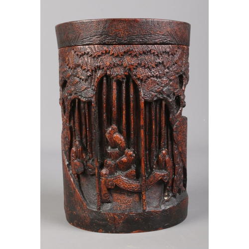 86 - A 19th century carved bamboo lidded brush pot, decorated with figures in landscape scenes.