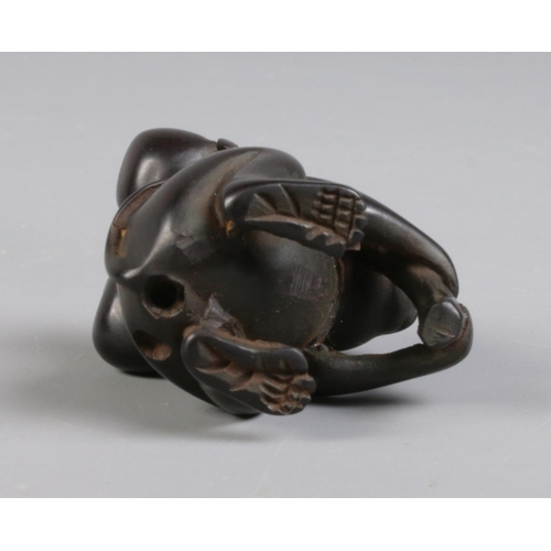 93 - A carved wood netsuke formed as a monkey carrying fruit.