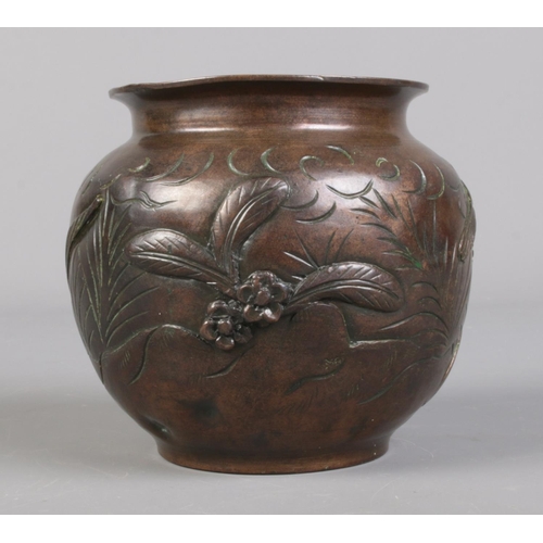 98 - A Japanese bronze pot moulded in relief with birds and flowers. Height 10cm.