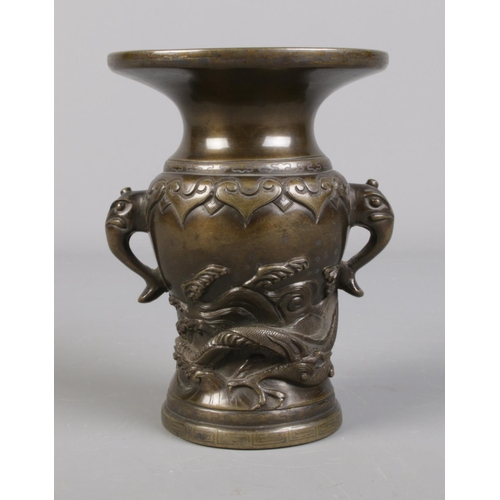 99 - A Japanese bronze vase decorated in relief with a dragon. 14cm.