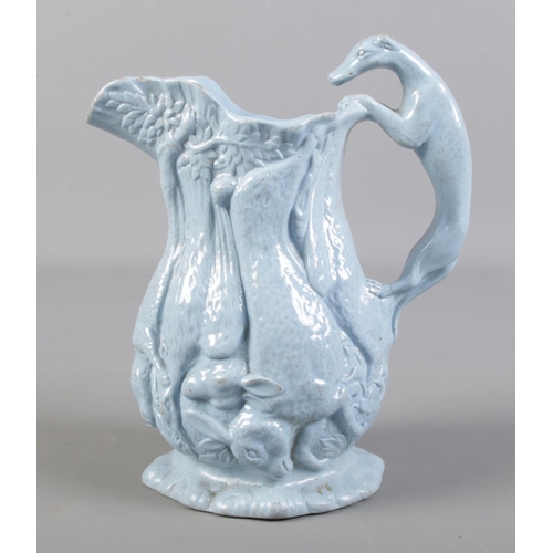 303 - A 19th century Staffordshire jug with greyhound handle and relief moulded game decoration.