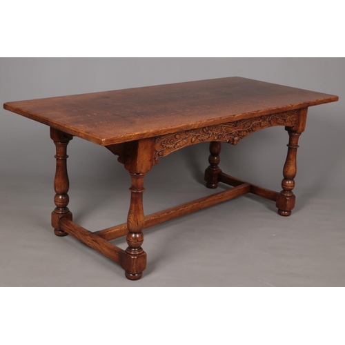 650 - A carved oak refectory dining table. Decorated with carved acorns and raised on turned supports. Pos... 