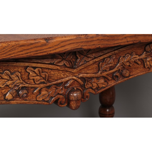 650 - A carved oak refectory dining table. Decorated with carved acorns and raised on turned supports. Pos... 