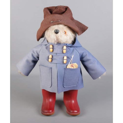 300 - A Paddington Bear teddy. In blue duffel coat and red wellington boots,  design registration No. 9578... 