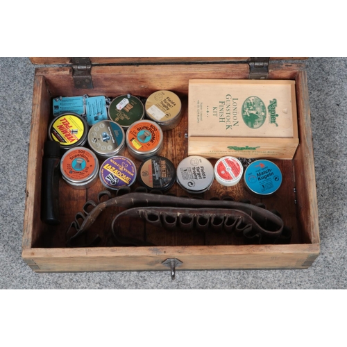 173 - A wooden ammunition box with contents. To include tins of pellets, cartridge belt and gun care kit.