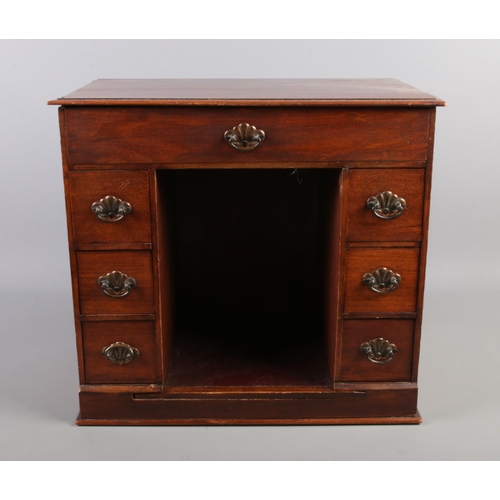 65 - A mahogany apprentice knee hole desk with contents of bobbins. (37cm x 40cm x 24cm)