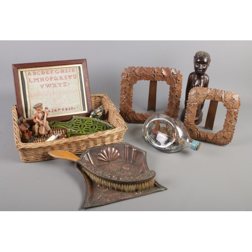 70 - A basket of collectables. Includes Benin carving, ship in bottle, crumb scoop and brush, framed samp... 