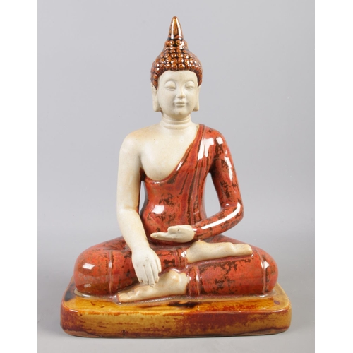 80 - A ceramic and glazed figure of a seated Buddha. H:28cm W:20cm.