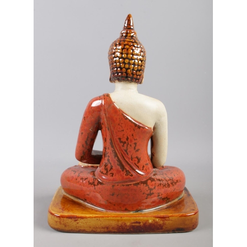 80 - A ceramic and glazed figure of a seated Buddha. H:28cm W:20cm.