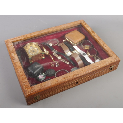 93 - A bijouterie case with contents to include Swiza clock, watches, antique brooches etc.