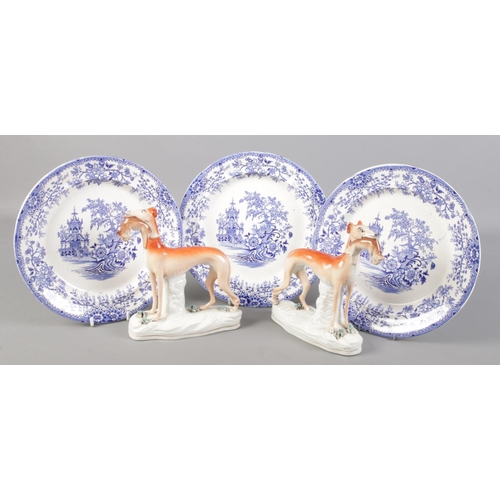 129 - A pair of Staffordshire grey hounds along with three blue and white Colandine plates.