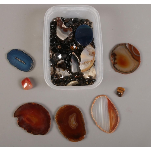 124 - A quantity of loose gemstones. Including tigers eye, agate slices, etc.