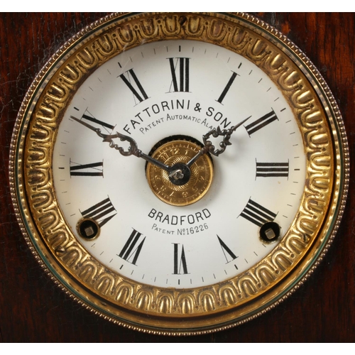 130 - A carved oak Fattorini & Sons mantel clock. Patent automatic alarm. With pendulum and key.