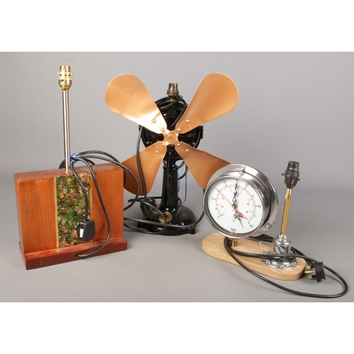 270 - Three decorative table lamps. Includes cast iron fan, pressure gauge lamp/clock and a teak example w... 