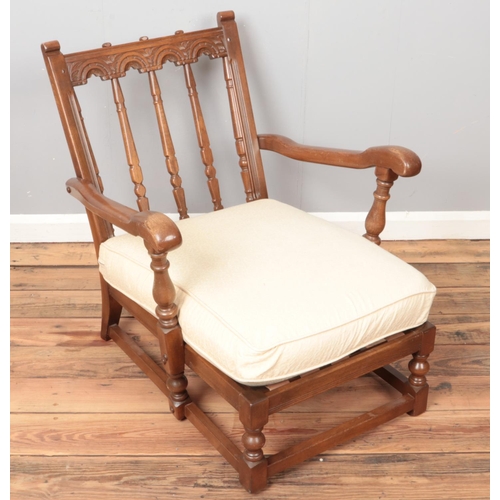 442 - A carved Ercol sofa along with matching armchair. Both with cream upholstery.