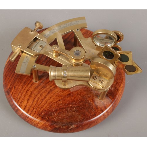 102 - A brass sextant mounted on oak plinth.