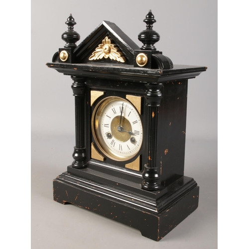 176 - A black and gilt mantel clock with Roman numeral markers.