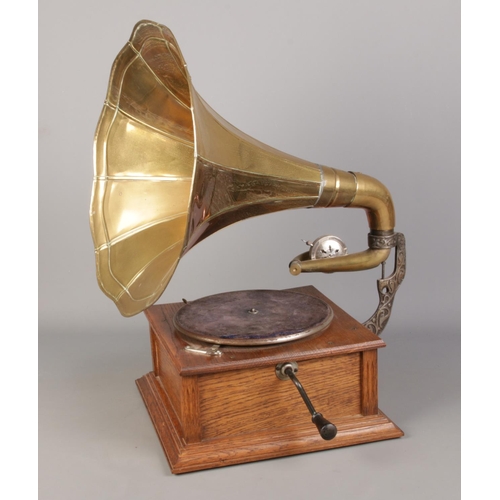 37 - A portable wind up gramophone with oak base and brass funnel. In working order.