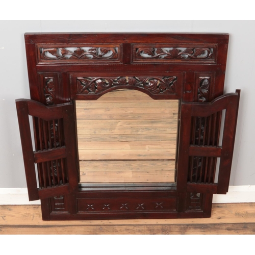 326 - A large Indonesian carved hardwood hinged shutter door mirror. Height: 88cm, Width: 78cm.