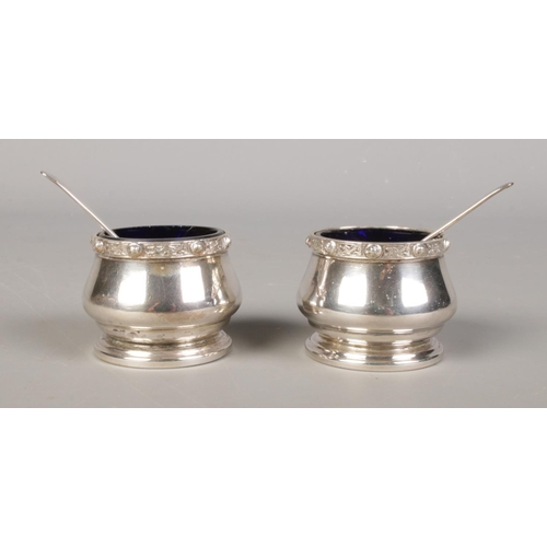 389 - A pair of silver salts, with decorated rims and glass liners; together with silver spoons. Salts ass... 