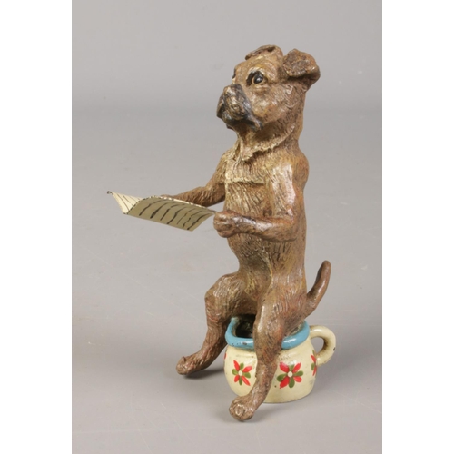 402 - In the style of Franz Bergmann (1861-1936), a cold painted bronze of a dog seated on a potty reading... 