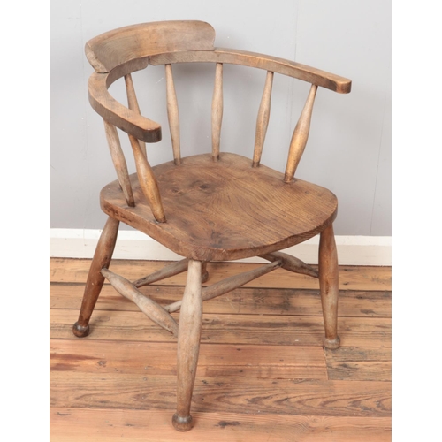 426 - A carved oak smokers bow armchair.