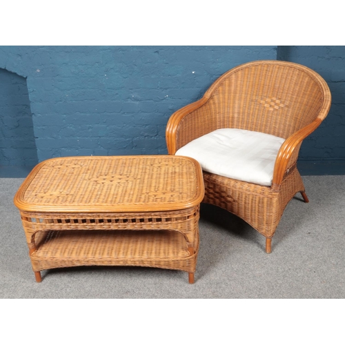 520 - A cane and rattan conservatory suite. Comprising of a two seat sofa, armchair and coffee table. Sofa... 