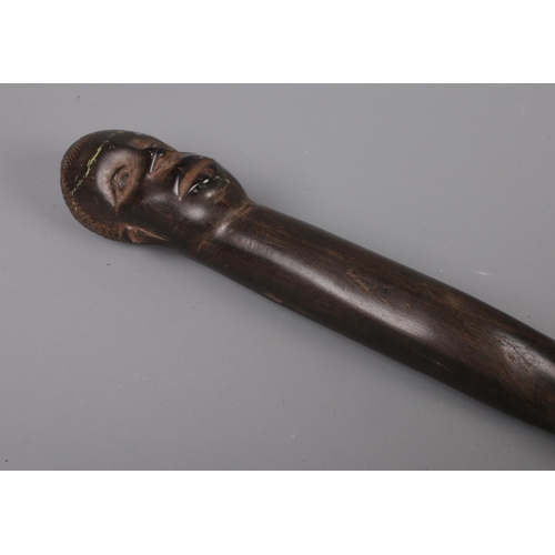 69 - A carved African ebonised barley twist walking stick with mask head handle. (97cm)