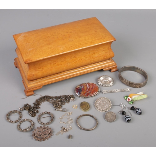 479 - An oak casket with contents of silver and white metal jewellery.