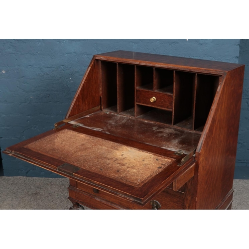 533 - A small oak bureau with turned supports.