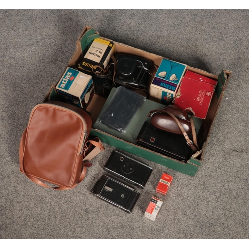 215 - A box of assorted photographic equipment including a selection of cameras, bulbs and film.