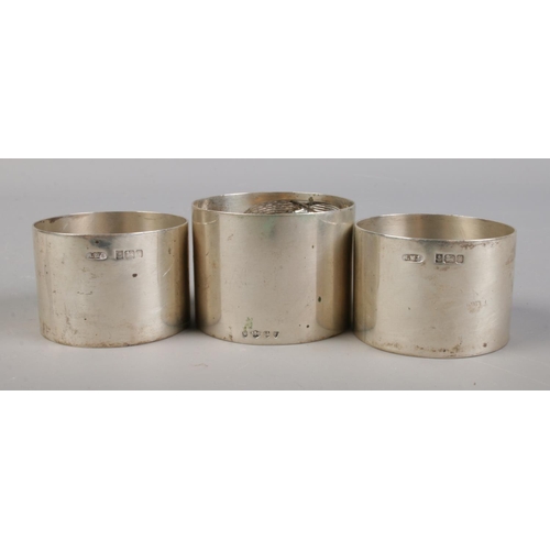 363 - A trio of silver napkin rings, including one matching pair (Assayed Birmingham 1984). Single ring ha... 