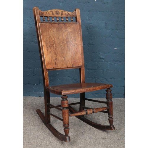 490 - An oak and ply panel and spindle back rocking chair.